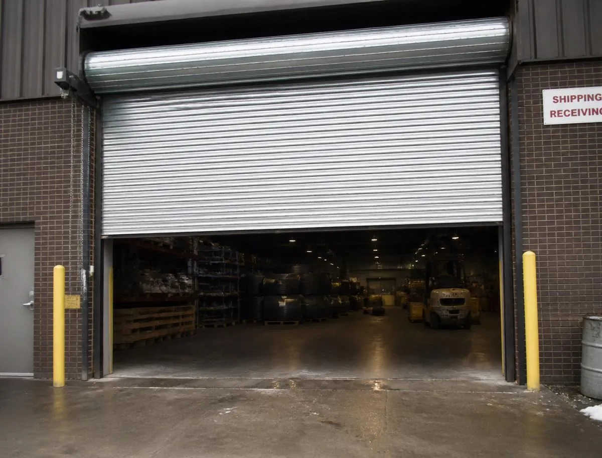 Large rolling steel commercial overhead door at a warehouse loading dock